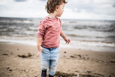蹒跚学步的小男孩站在海滨
